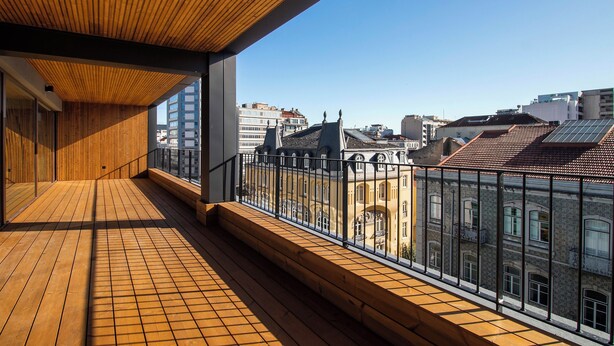 Ein Holzbalkon mit Blick auf Stadtgebäude.