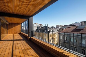 Ein Holzbalkon mit Blick auf Stadtgebäude.