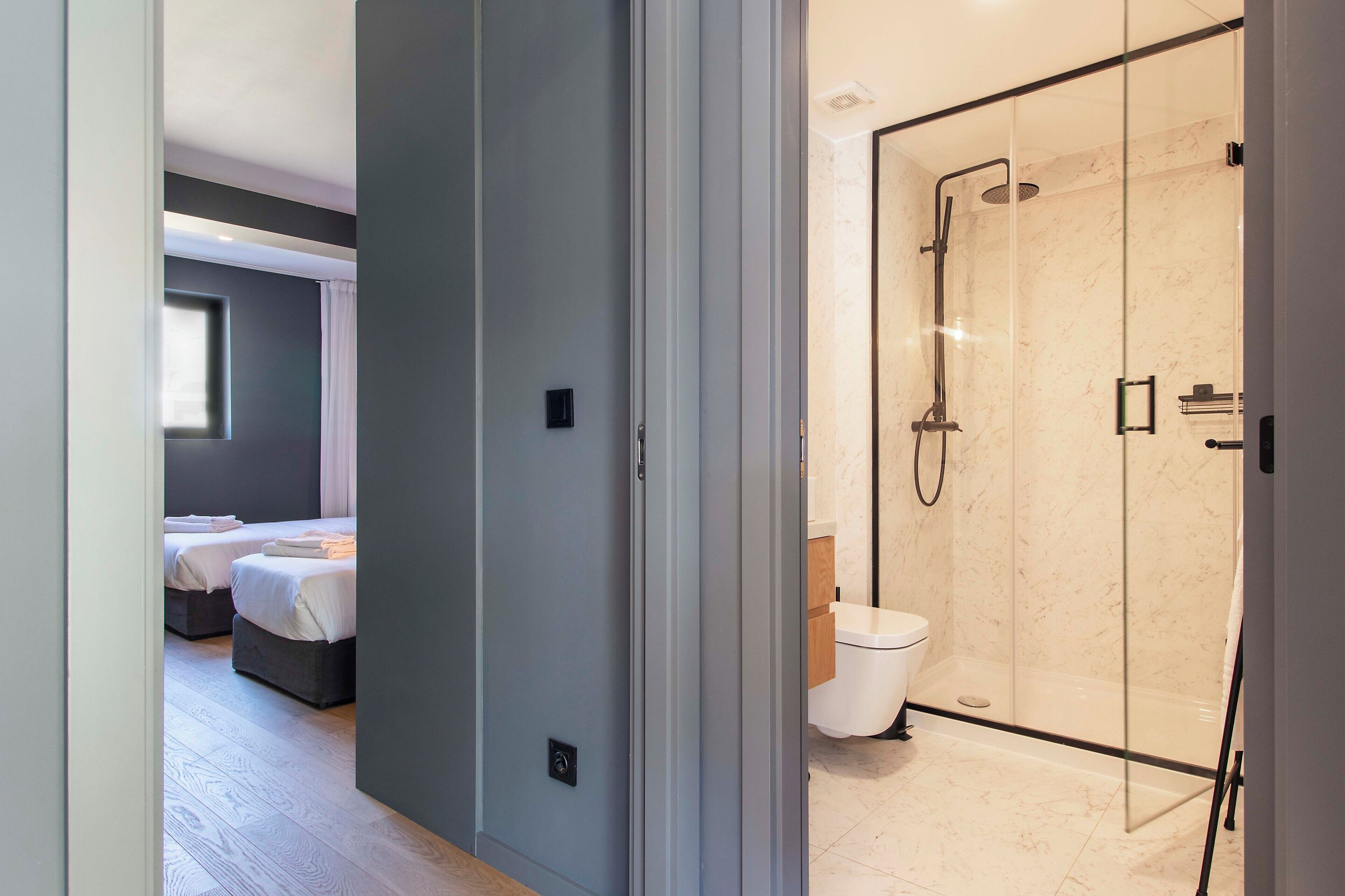 Une salle de bain moderne avec une douche à parois de verre, des toilettes et un lavabo.