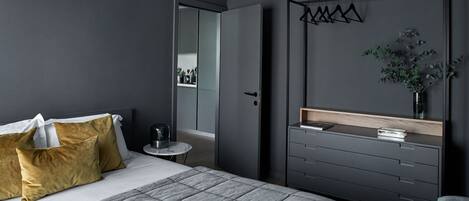 Un dormitorio moderno con cama, mesita de noche y armario.