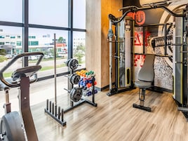 A gym with exercise equipment, a treadmill, and a view of the outside.