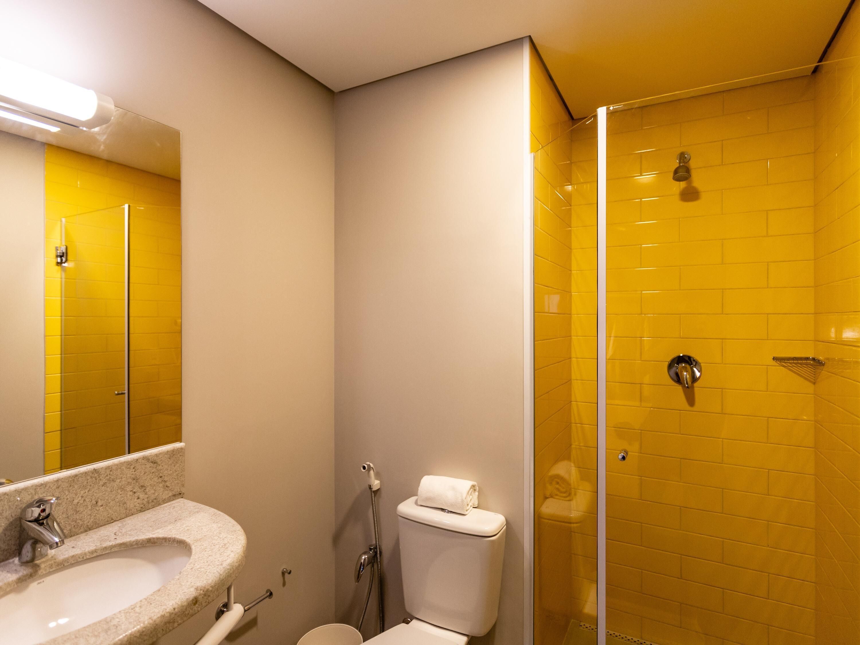 A bathroom with a sink, toilet, and a glass-enclosed shower.