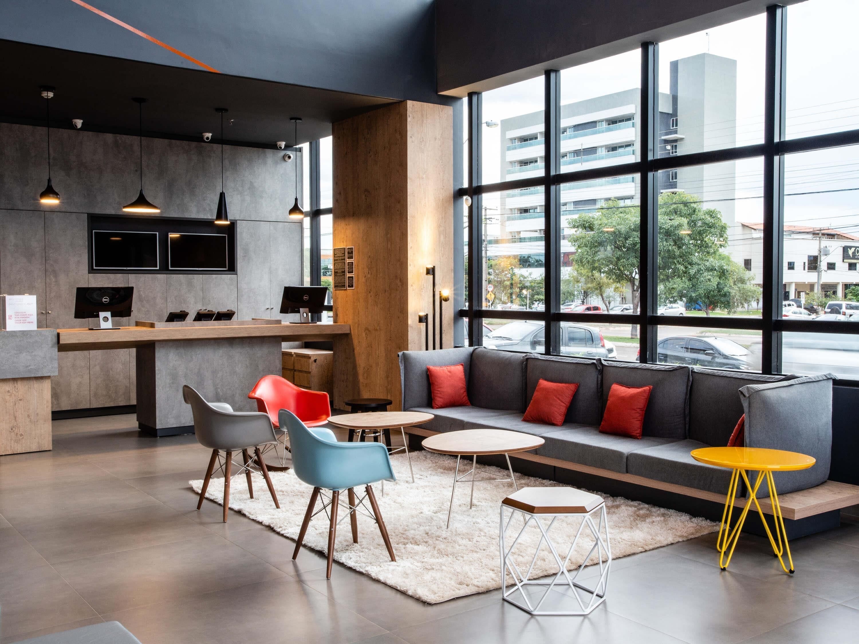 Un interior moderno con una zona de estar, un bar y grandes ventanales con vistas a la ciudad.