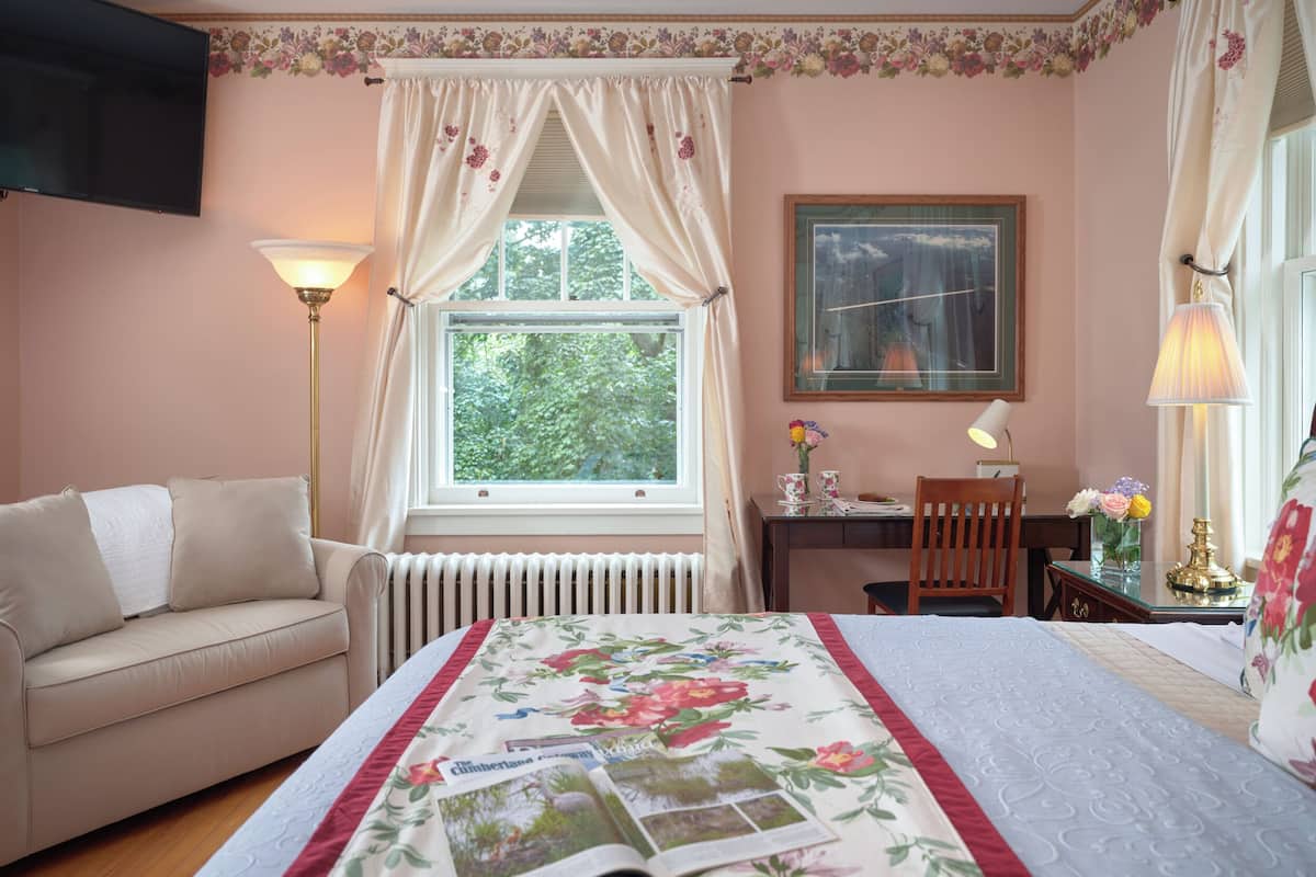 Ein Zimmer mit einem Bett, einem Sofa, einem Schreibtisch und einem Stuhl.