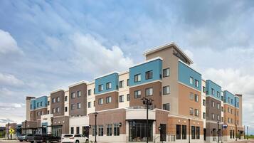 A multi-story hotel with a modern design, featuring a mix of brick and blue facade, large windows, and a prominent entrance with a sign.