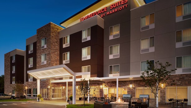 A hotel with a stone facade, outdoor seating area, and a covered entrance. - TownePlace Suites by Marriott Janesville (Janesville)