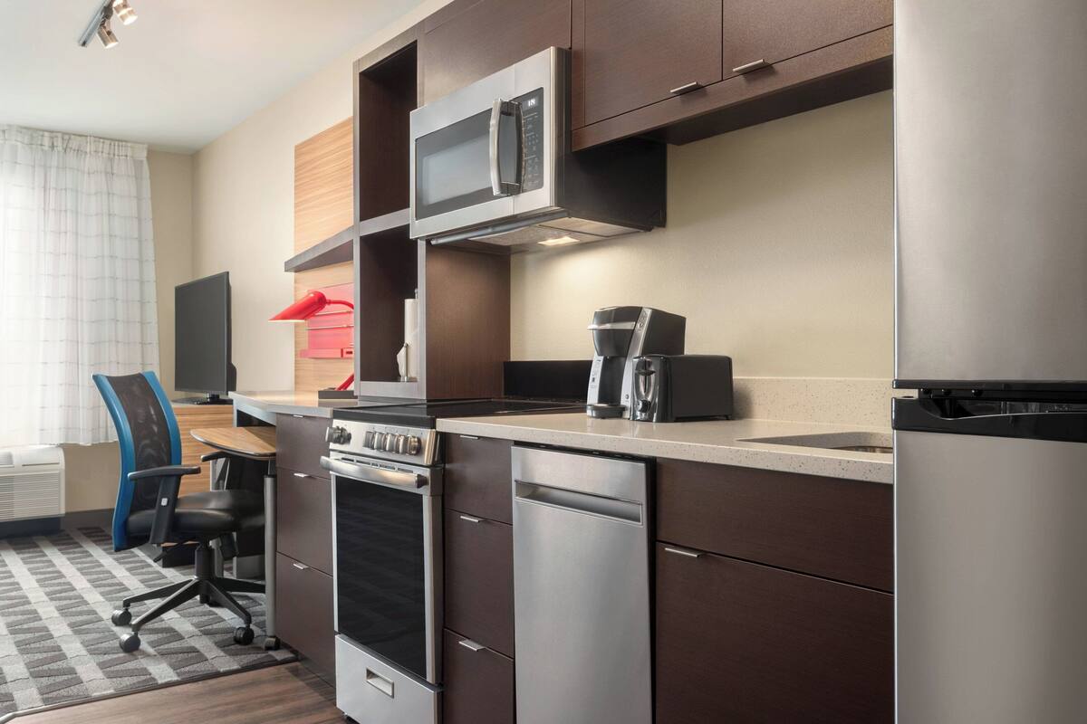 A compact kitchen with a microwave, coffee maker, and dishwasher.
