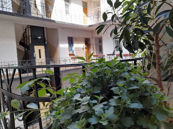 Un immeuble à plusieurs étages doté de balcons, d’un escalier et offrant une vue sur la rue.