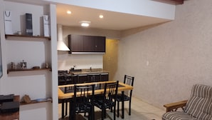 A compact living space with a dining area, kitchen, and seating area.