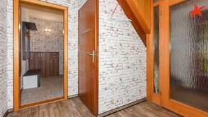A room with a wooden door, white brick-patterned walls, and a wooden floor. - Vacation apartment Seestern - Holiday apartments Der Seehund, Haus Kajedeich in (Esens)