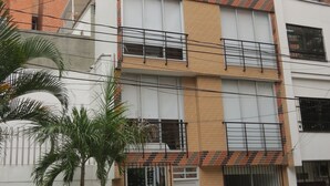 A multi-story residential building with a brick facade, balconies, and a gated entrance. - Apartamentos MED (Medellín)