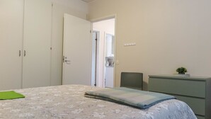 A bedroom with a bed, a dresser, a chair, and a door leading to a bathroom. - Itäkoski 1 by Interhome (Keminmaa)