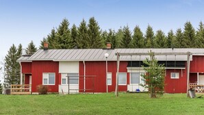 A red building with a metal roof, surrounded by a grassy area and trees. - Itäkoski 1 by Interhome (Keminmaa)