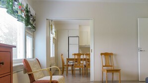 A room with a dining area, a kitchen, and a door leading to another room. - Itäkoski 1 by Interhome (Keminmaa)