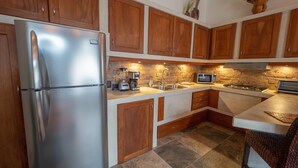 A kitchen with wooden cabinets, a stainless steel refrigerator, a microwave, and a stove. - Luxury Beachfront Mar Arena 2 (Jacó)