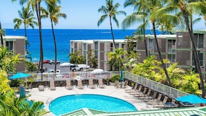 A resort with a pool, lounge chairs, and a view of the ocean. - 🏖️Beautiful Ocean Views | Top Floor | Concierge Included (Kailua Kona)