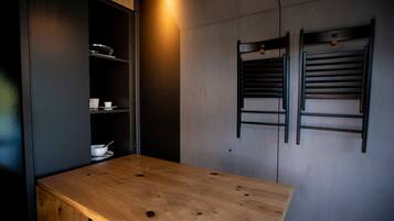 Een moderne keuken met een houten aanrecht, inbouwplanken en een wandrek.
