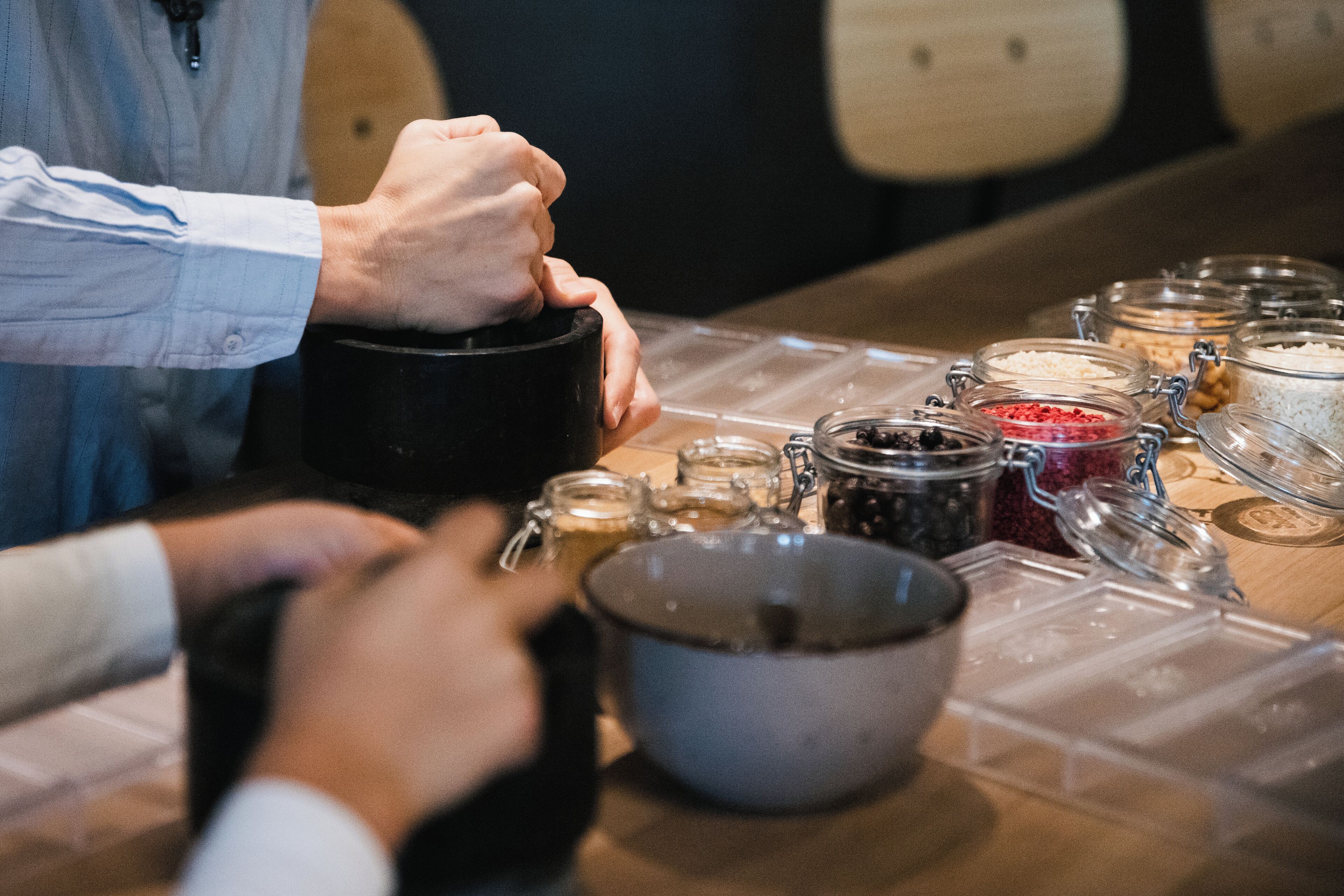A table with various food containers and a person holding a black mug.