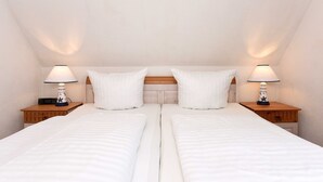 A twin room with two single beds, each with a wooden nightstand and a lamp.