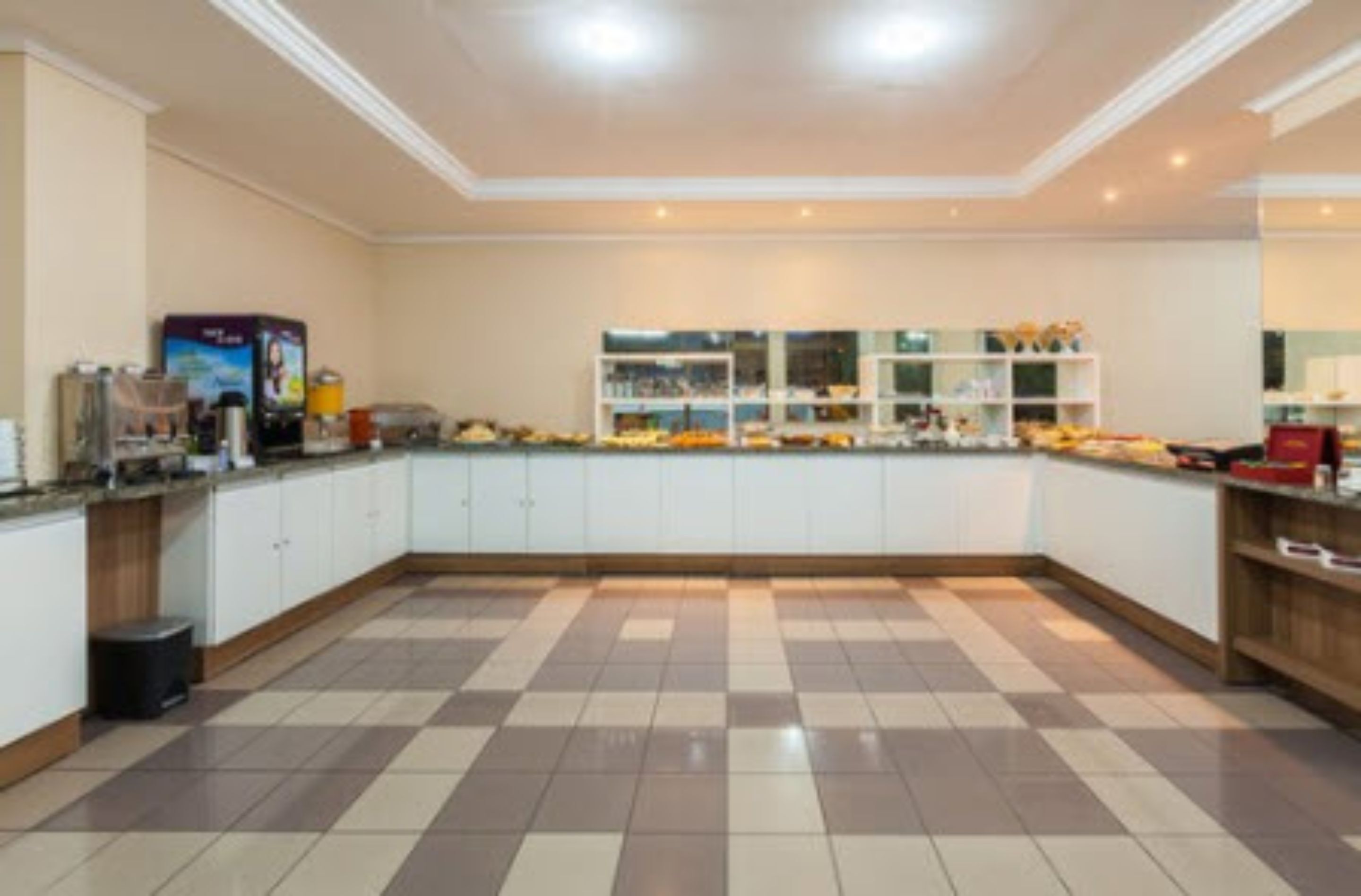 A spacious kitchen with a checkered floor, white cabinets, and a central island.