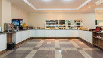 A spacious kitchen with a checkered floor, white cabinets, and a central island.