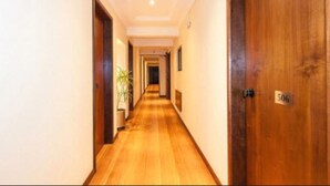 A hallway with wooden flooring, a potted plant, and a door labeled '506'.