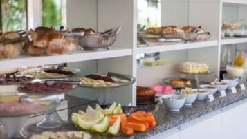 A buffet with various food items including fruits, cheeses, and breads.