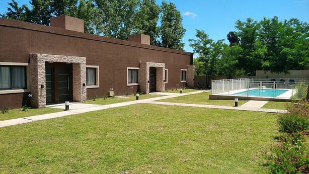 Un bâtiment moderne doté d’une piscine, d’une pelouse bien entretenue et surplombant un ciel dégagé.