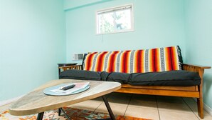 A living room with a sofa, a coffee table, a rug, and a window. - 2330/a (San Diego)