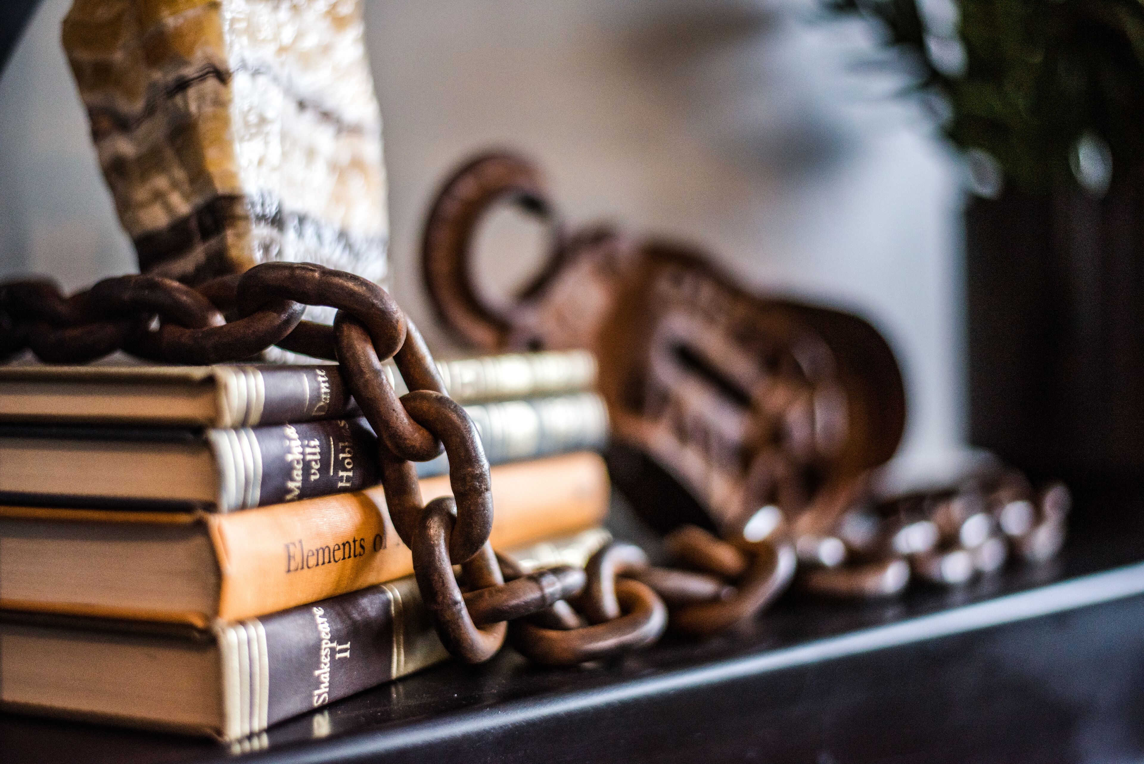 A stack of books with a chain and a key on top.