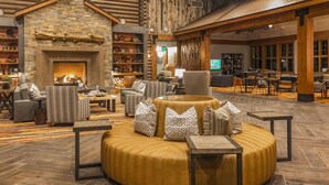 A spacious lobby with a stone fireplace, comfortable seating, and a television screen. - Hyatt Vacation Club at The Ranahan (Breckenridge)