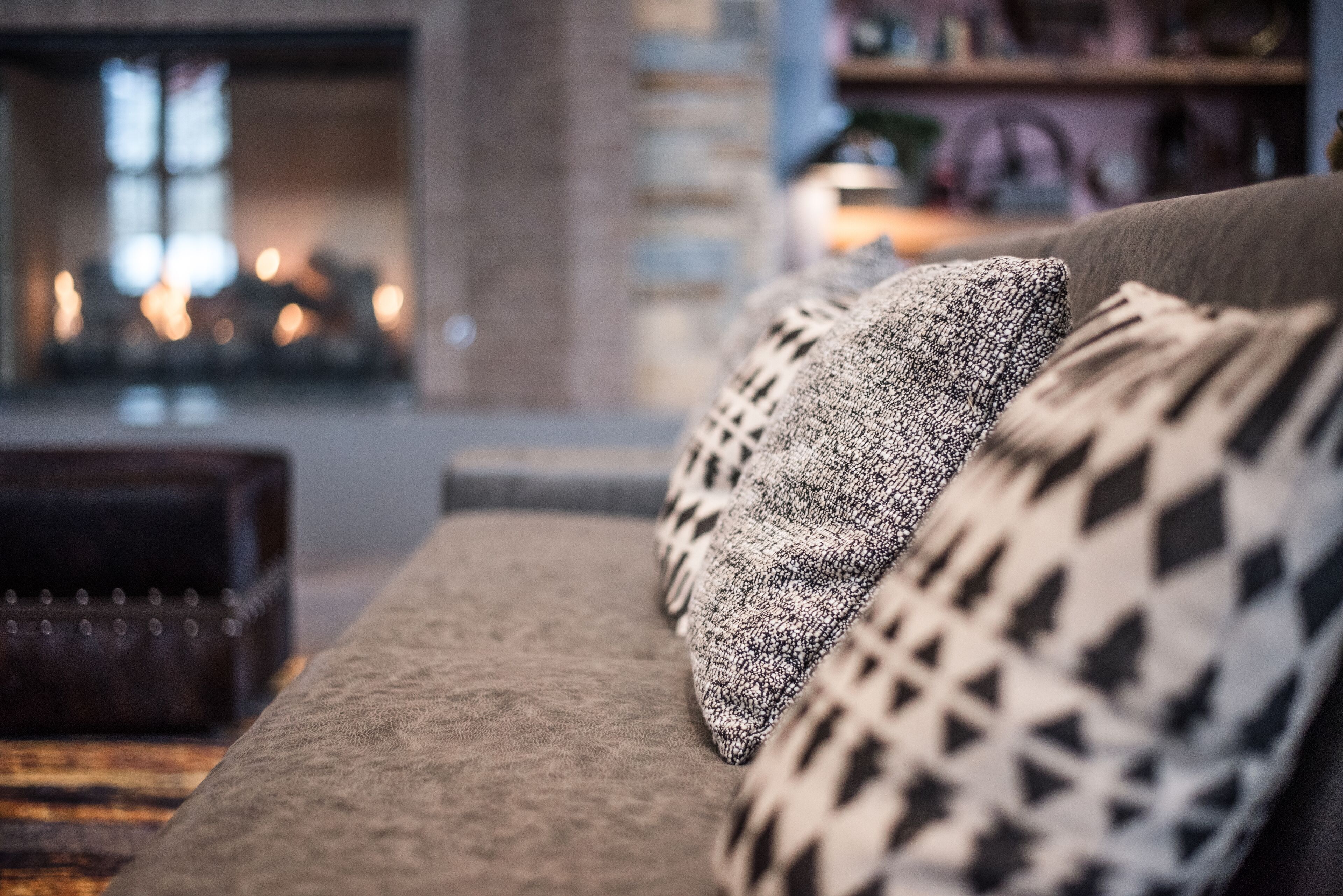 A cozy living room with a sofa and patterned cushions.