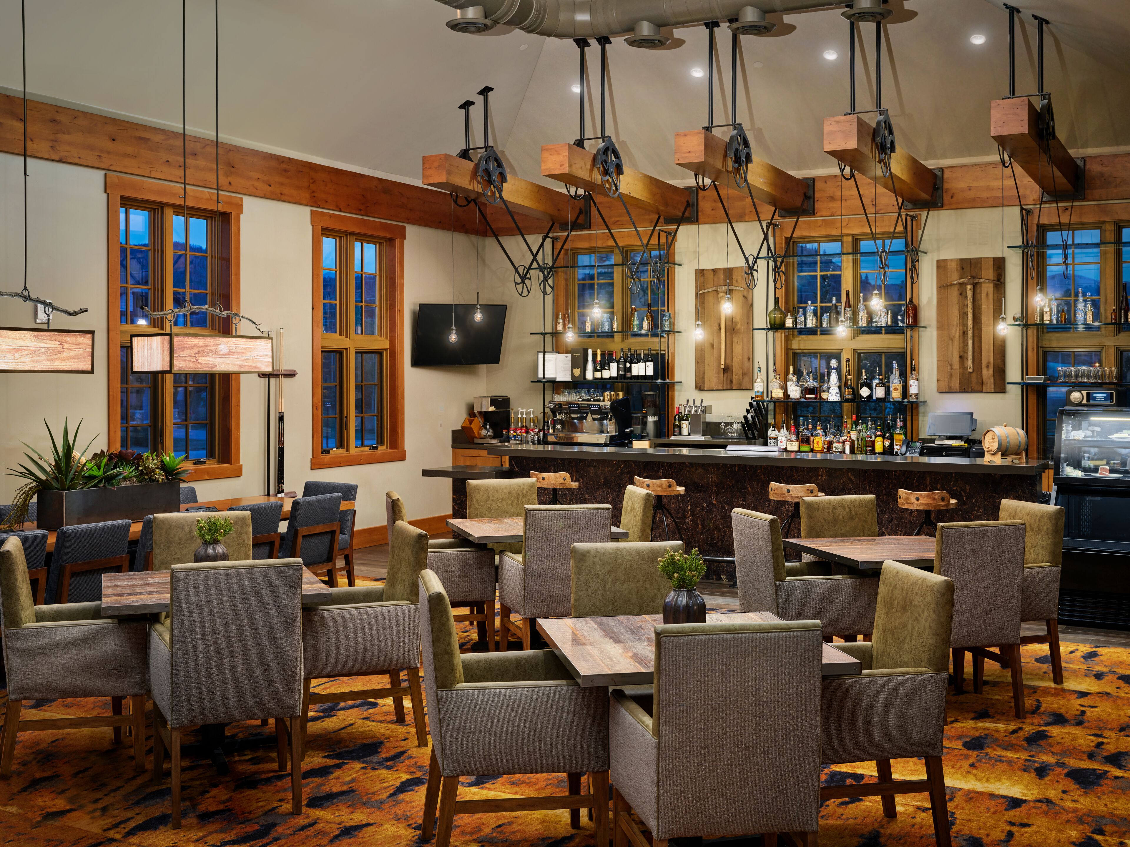 A restaurant with a bar area, wooden beams, and a large window.