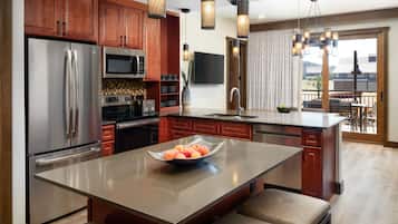 A modern kitchen with stainless steel appliances, wooden cabinets, and a large island with seating.