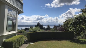 A house with a view of the sea, surrounded by well-maintained hedges and a lawn. - Perfect Getaway overlooking the Puget Sound, Close to Ruston Point and UPS (Tacoma)