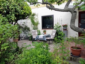 A patio with a table and chairs, a potted plant, and a window. - Apartment Käding in Kappeln an der Schlei - Apartment Käding in Kappeln an der Schlei (Kappeln)