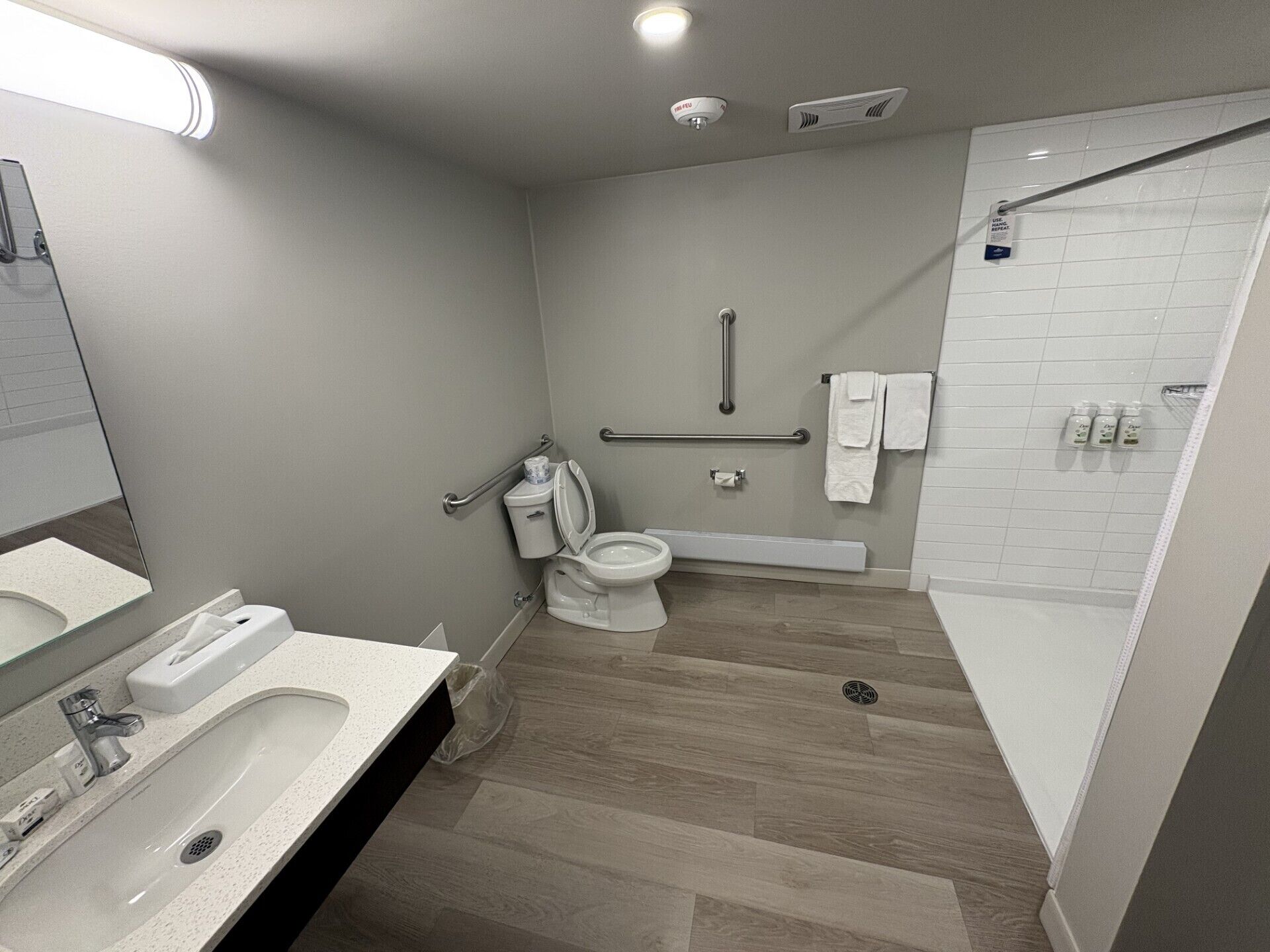 A modern bathroom with a toilet, sink, and shower.