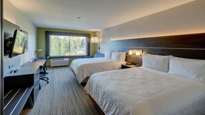A hotel room with two beds, a desk with a computer, a TV, and a window with a view of trees. - Holiday Inn Express & Suites Auburn Downtown by IHG (Auburn)