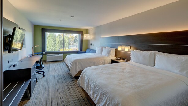 A hotel room with two beds, a desk with a computer, a TV, and a window with a view of trees. - Holiday Inn Express & Suites Auburn Downtown by IHG (Auburn)