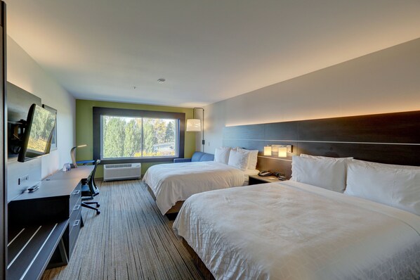 A hotel room with two beds, a desk with a computer, a TV, and a window with a view of trees. - Holiday Inn Express & Suites Auburn Downtown by IHG (Auburn)