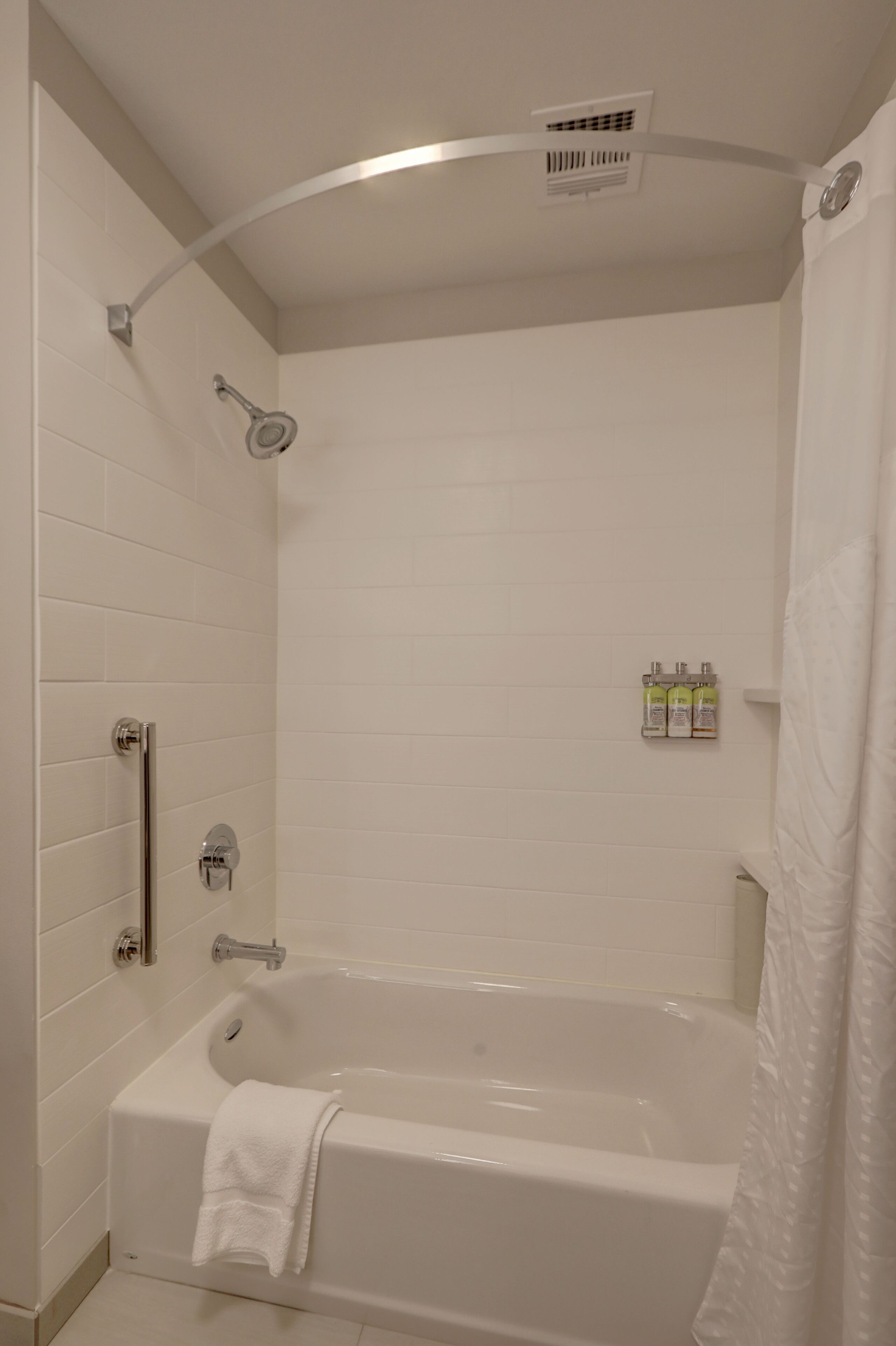 Un baño moderno con bañera, cabezal de ducha y toallero.