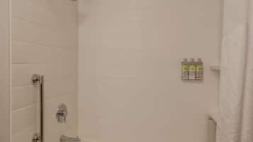 Un baño moderno con bañera, cabezal de ducha y toallero.