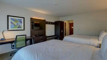 A hotel room with two beds, a desk with a chair, a TV, and a framed picture on the wall.