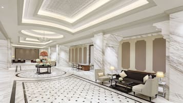 A luxurious lobby with marble flooring, a central floral arrangement, seating areas, and a high ceiling with intricate designs.