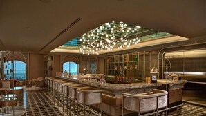 A modern bar area with a checkered floor, bar stools, and a large overhead light fixture. - ITC Royal Bengal, a Luxury Collection Hotel, Kolkata (Kolkata)