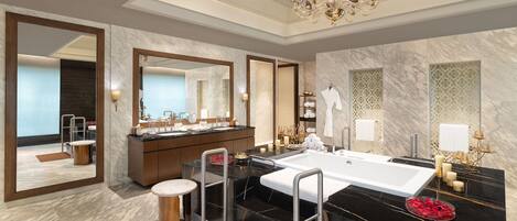 A modern bathroom with a large mirror, a bathtub, and a vanity with a sink.