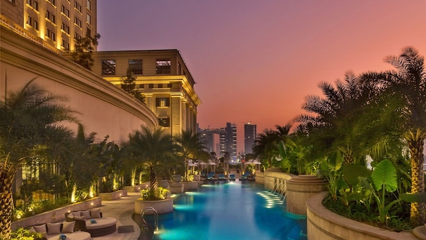 A swimming pool with lounge chairs and palm trees, surrounded by buildings. - ITC Royal Bengal, a Luxury Collection Hotel, Kolkata (Kolkata)