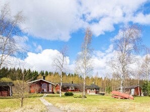 A cabin with a wooden deck, surrounded by trees and a clear sky. - Vacation home Eden by Interhome (Laukaa)