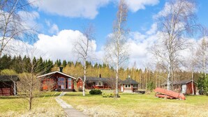 A cabin with a wooden deck, a small garden, and a canoe. - Vacation home Eden by Interhome (Laukaa)