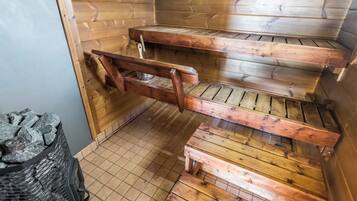 Un sauna en bois, avec des bancs et un sol carrelé.